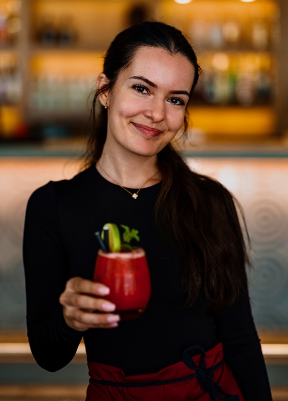 Barmanka Masali wznosi toast czerwonym koktajlem